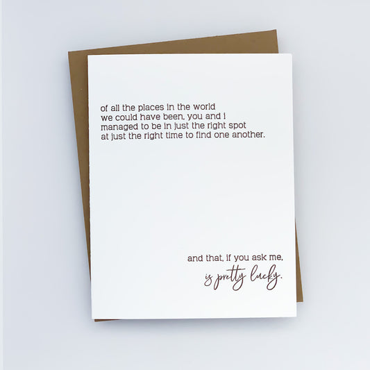 A white letterpress card with black text, featuring the phrase 'Of all the places in the world we could have been, you and I managed to be in just the right spot at just the right time to find one another. And that, if you ask me, is pretty lucky.