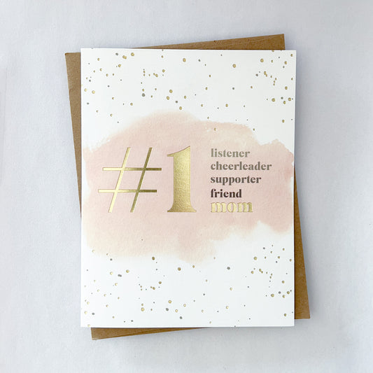 A mothers day card with gold foil dots on a white background with text that reads '#1 listener cheerleader supporter friend mom'