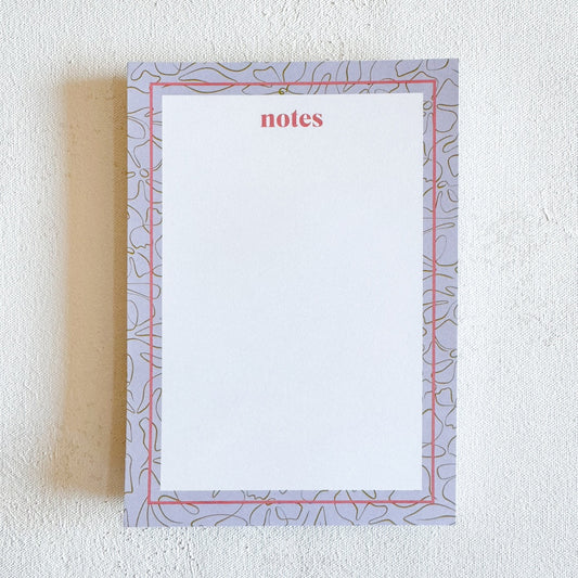 A floral patterned bordered notepad with the word 'notes' written in pink, with a purple, green, and magenta color scheme.