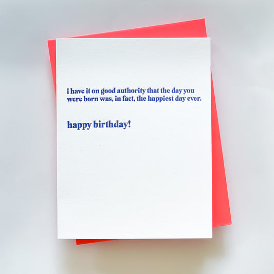 A blue letterpress birthday card with a neon coral pink envelope, featuring the text 'I have it on good authority that the day you were born was, in fact, the happiest day ever. Happy birthday!' 