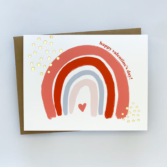 A valentine card with a hand-painted rainbow design and 'Happy Valentine's Day!' text, accented with gold foil polka dots, presented against a white background.