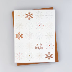 A holiday card with a white background featuring rust color snowflake patterns with the text 'All is bright'.