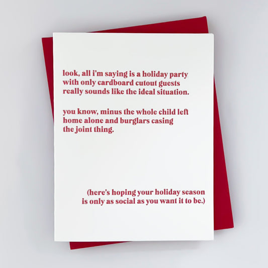 A greeting card with a red envelope, featuring a white background and red text that reads 'Look, all I'm saying is a holiday party with only cardboard cutout guests really sounds like the ideal situation. You know, minus the whole child left home alone and burglars casing the joint thing. (here's hoping your holiday season is only as social as you want it to be.)'