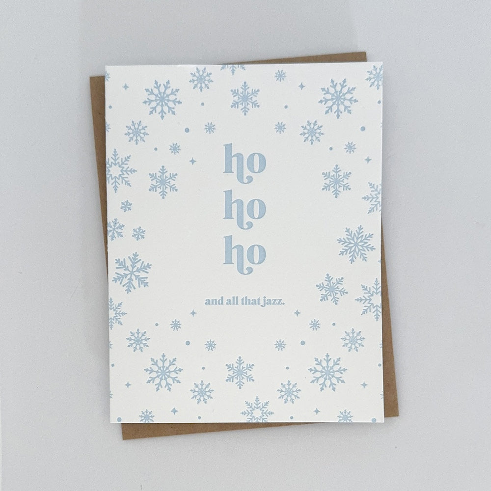 A Holiday Card with a white background featuring light blue snowflakes surrounding text that reads 'ho ho ho and all that jazz'