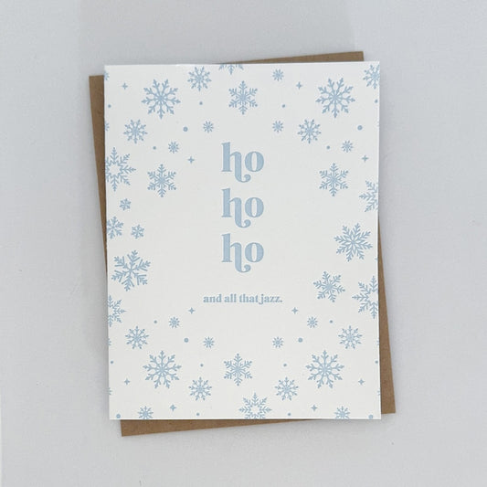 A Holiday Card with a white background featuring light blue snowflakes surrounding text that reads 'ho ho ho and all that jazz'