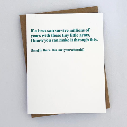 A letterpress card with a teal text that reads 'If a T-rex can survive millions of years with those tiny little arms, I know you can make it through this. (Hang in there. this isn't your asteroid.)'.